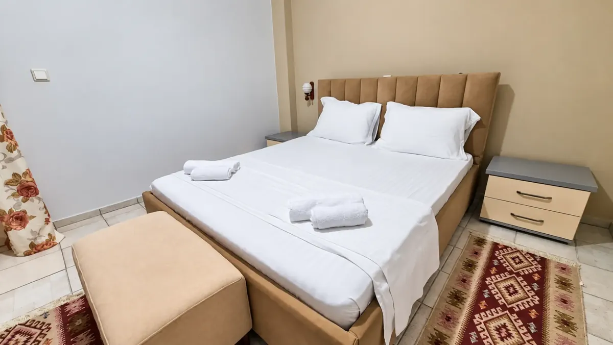 Dhomë dyshe e rehatshme me peshqirë të freskët dhe dritë të ngrohtë